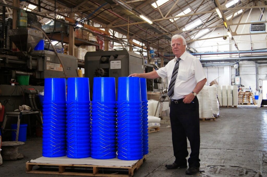 Managing Director stood next to a supply of plastic buckets