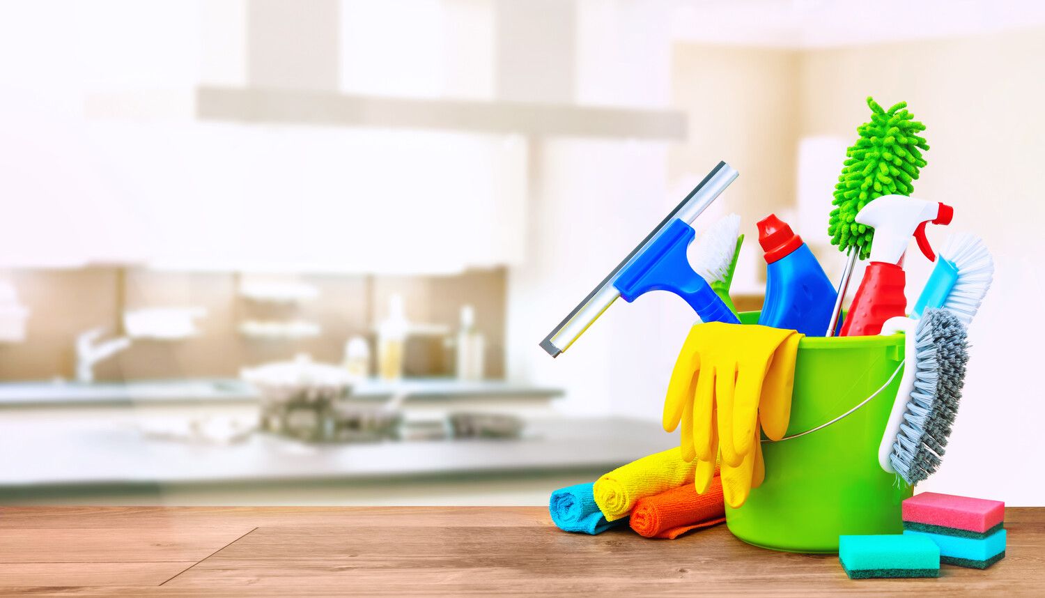 Cleaning materials gathered together in a bucket displayed in a kitchen