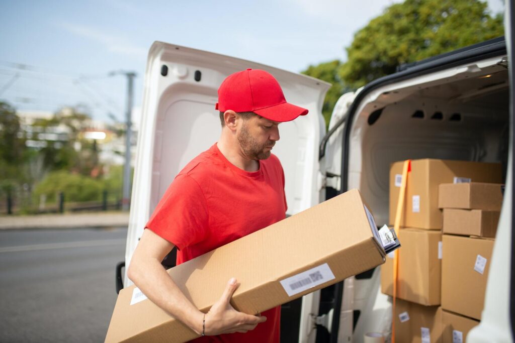 Delivery driver loading boxes into a van