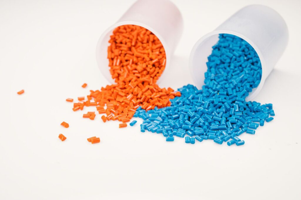 Two buckets of plastic granules spilling on to the ground